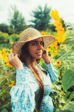 Ayçiçekleri arasında tarlada yürüyün