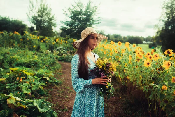 Ayçiçekleri arasında tarlada yürüyün