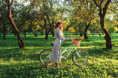 Gün batımında bisikletle parkta kız