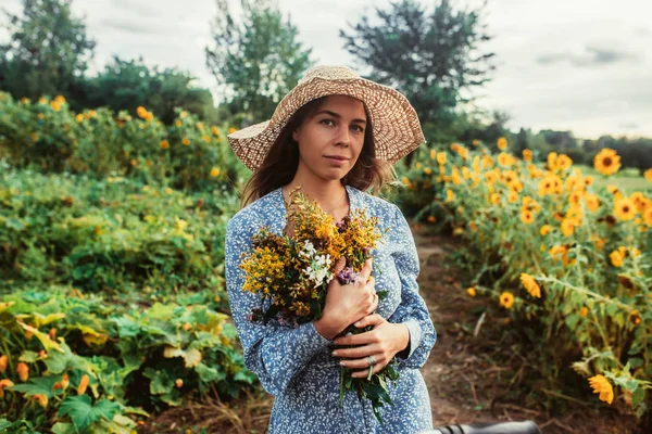 Ayçiçekleri arasında tarlada yürüyün