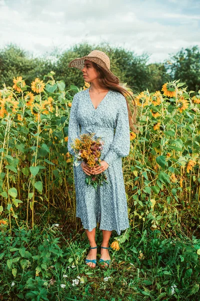 Ayçiçekleri arasında tarlada yürüyün
