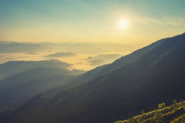 Dağların manzarasında renkli bir günbatımı. Dramatik bulutlu gökyüzü.