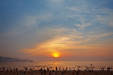 Danang, Vietnam: 9 Mayıs 2019 - Danang, Vietnam plajları. Turistler eğlenerek oynarlar. Sabah güneş doğuyor.