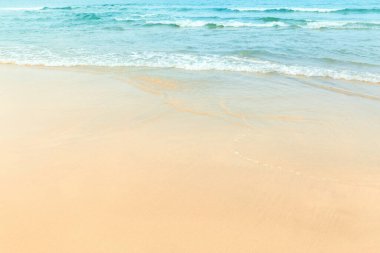 Güneşli günlerde deniz dalgaları olan sahil.