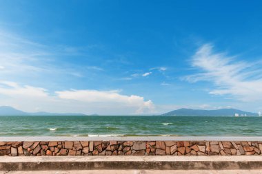 Gökyüzünün mavi olduğu gün deniz sahilinde taştan yapılmış yürüyüş yolları.