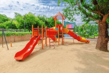 Bir çocuk parkı, kumsalda bir sürgülü kaydırak..