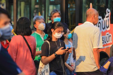 Bangkok - Tayland, 29 Şubat 2020: Tıbbi maske takan insanlar tozu ve mikrobu önler. Akşam güneş ışığı vardı.