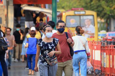 Bangkok - Tayland, 29 Şubat 2020: Tıbbi maske takan insanlar tozu ve mikrobu önler. Akşam güneş ışığı vardı.