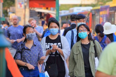 Bangkok - Tayland, 29 Şubat 2020: Tıbbi maske takan insanlar tozu ve mikrobu önler. Akşam güneş ışığı vardı.
