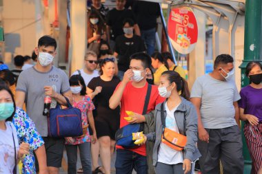 Bangkok - Tayland, 29 Şubat 2020: Tıbbi maske takan insanlar tozu ve mikrobu önler. Akşam güneş ışığı vardı.