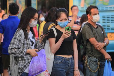 Bangkok - Tayland, 29 Şubat 2020: Tıbbi maske takan insanlar tozu ve mikrobu önler. Akşam güneş ışığı vardı.