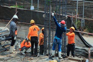 İnşaat işçisi ve yüksek binaların inşaat alanında çalışıyor..