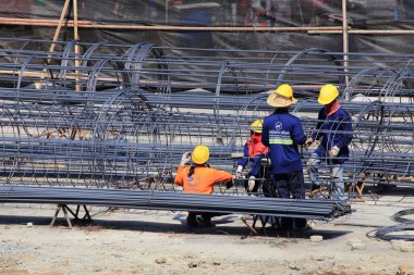 İnşaat işçisi ve yüksek binaların inşaat alanında çalışıyor..