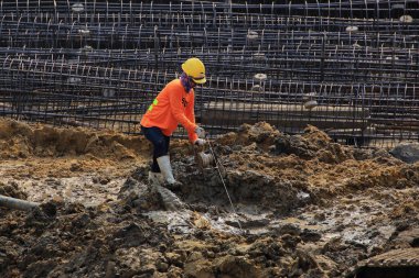 İnşaat işçisi ve yüksek binaların inşaat alanında çalışıyor..