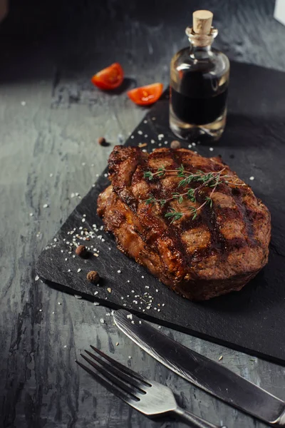 Pork steak with sauce on the slate Board side view