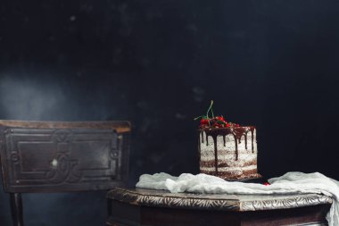 Bir masada kırmızı kuş üzümü ile çikolatalı kek