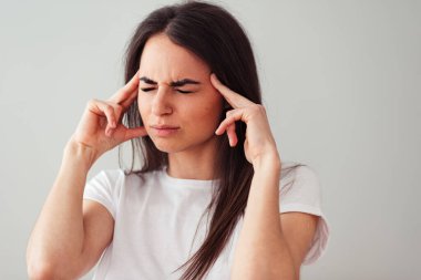 Kız düşüncenin gücünü yok etmeye çalışıyor, hafif bir arkaplanda gözlerini kısarak. Başım ağrıyor.