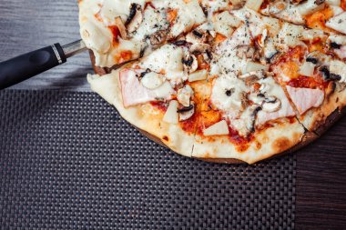 Sosisli, mantarlı ve mozzarellalı pizza. Üst Manzara. Bir dilim pizzayı kaldıran bir spatula. Metnin için boş yer.
