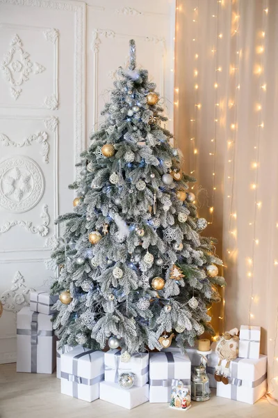 İç kısımlarında altın oyuncaklar olan karla kaplı Noel ağacı ile Bokeh ile kaplanmış beyaz kaplama kaplama kaplama..