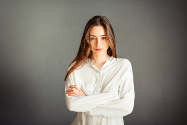 Gri arka planda beyaz gömlekli genç bir kız. Gri duvarların arkasında beyaz bluzlu bir Fransız kadın. Rötuş yapmadan.