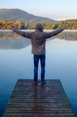 bir iskelede sırtında duran adam