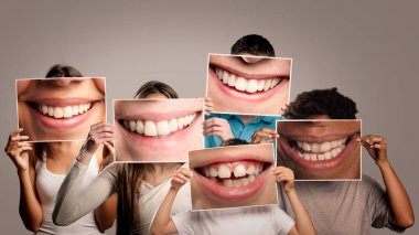 Bir grup mutlu insan ellerinde gri arka planda gülümseyen bir ağız resmi tutuyorlar.