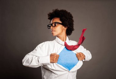 black woman opening her shirt like a superhero on a gray background clipart