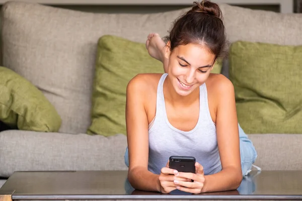 Giovane Ragazza Felice Che Legge Messaggio Uno Smartphone Sdraiato Nel — Foto Stock