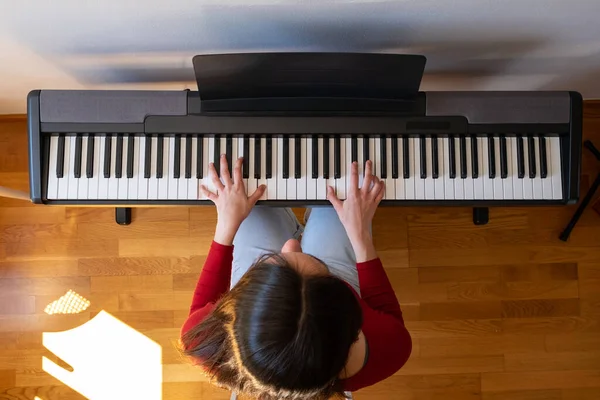 beautiful woman playing piano at home