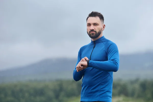 Handsome sportsman with smart watch outdoor