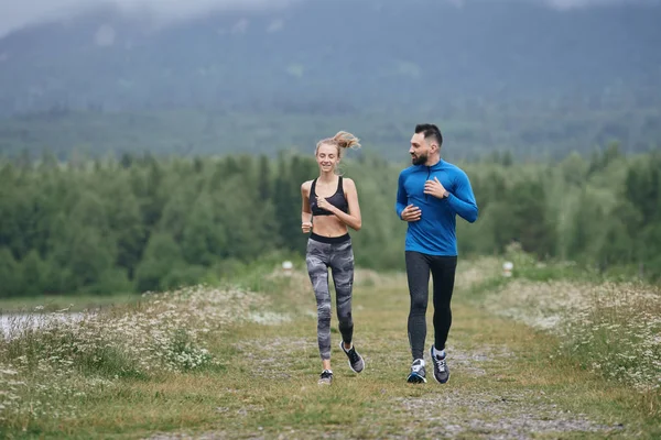 Happy couple doing cardio warm up outdoor on gloomy day