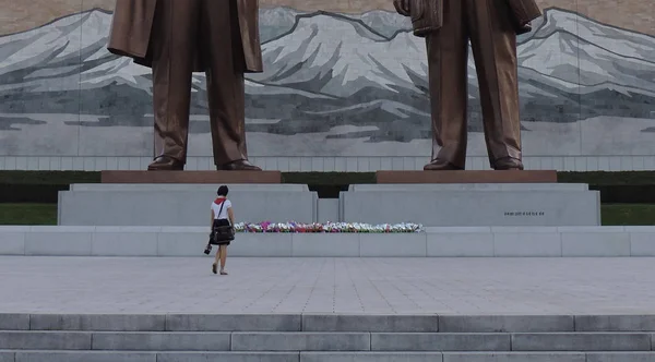 金正日と金日成の像に花を咲かせる北朝鮮の少女 — ストック写真