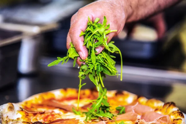 Close up hands of chef preparing pizza in the kitchen of a restaurant, cooking concept