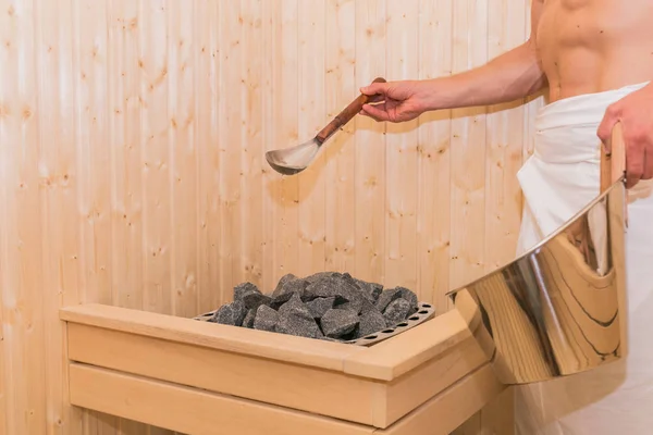 Jovem Está Derramando Água Pedra Quente Sala Spa Sauna — Fotografia de Stock