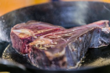 Izgara tava üzerinde biftek ızgarası. Mutfakta biftek pişirmek. Taze, lezzetli et 