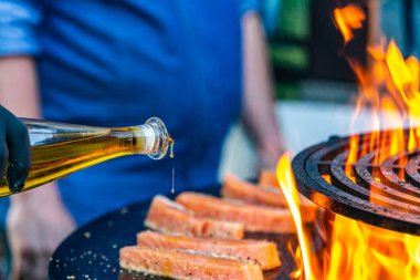 Aşçı somon lezzetli filete hazırlar ve yağ ekleyerek. Somon taze bir filete closeup