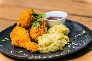 Siyah tabakta patatesli kızarmış tavuk. Restorandaki yemek. Yemek tasarımı ve restoran yemeği. 