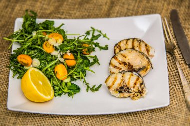 Tabakta taze sebzeli ızgara balık filetosu. Restorandaki yemek. Yemek tasarımı ve restoran yemeği. 