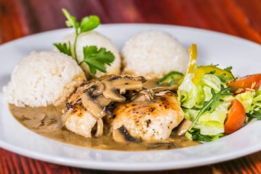 Mantar soslu tavuk göğsü ve pilav. Restorandaki yemek. Yemek tasarımı ve restoran yemeği.