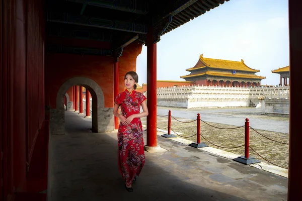 Chinese lady walk in red cheongsam dress in ancient Chinese forbidden palace, Beijing city, China, Asia. This photo can use for Travel in China asnd Asia concept