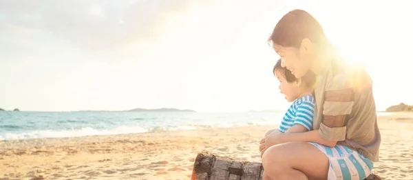 Mutter und Sohn sitzen zusammen am Strand — Stockfoto