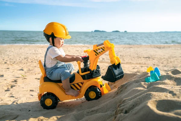 Asiático chico jugar un excavadora juguete en la playa — Foto de Stock