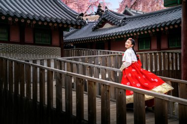 Hanbok elbiseli Koreli bayan eski bir sarayda koşuyor