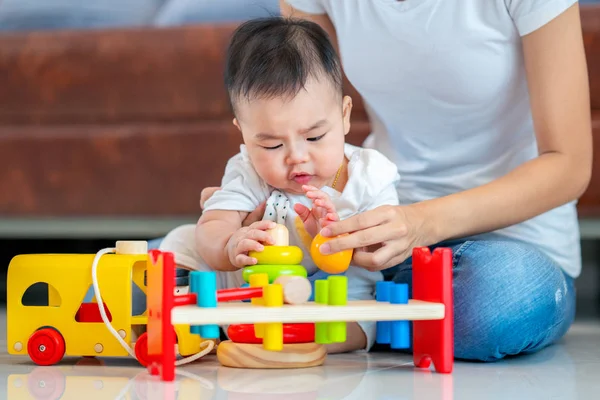 Madre jugar con su bebé por el juguete arbolado — Foto de Stock