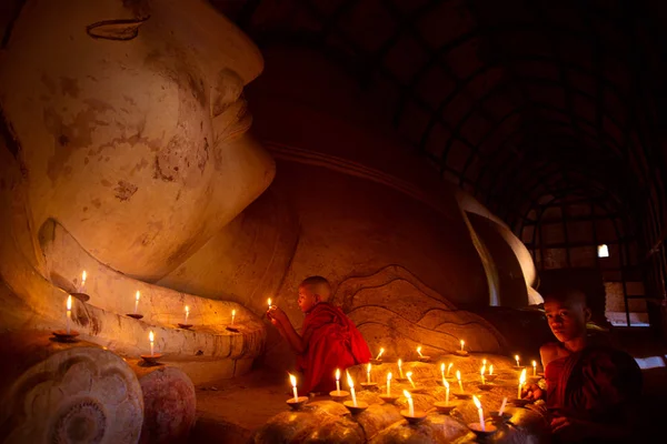 Mnich w starym mieście Bagan modlić się posąg Buddy z świeca — Zdjęcie stockowe
