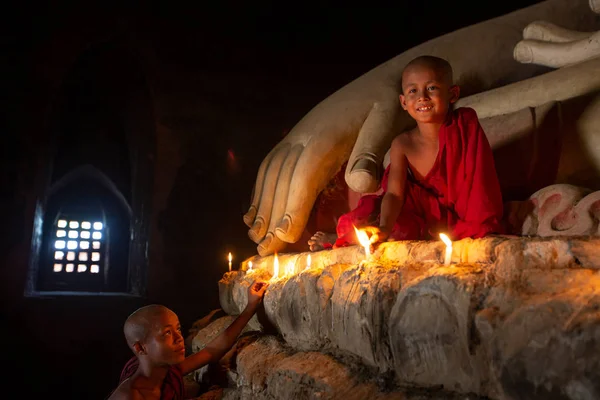 बागान जुन्या शहरातील भिक्षु मेणबत्तीसह बुद्ध पुतळा प्रार्थना करतात — स्टॉक फोटो, इमेज