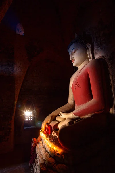 Mönch in der heidnischen Altstadt betet eine Buddha-Statue mit Kerze — Stockfoto