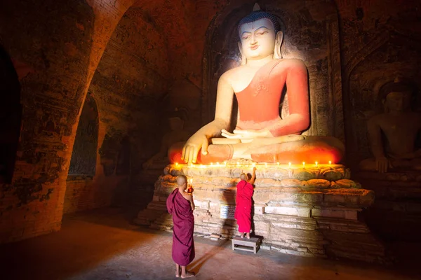 Monge em Bagan cidade velha rezar uma estátua buddha com vela — Fotografia de Stock