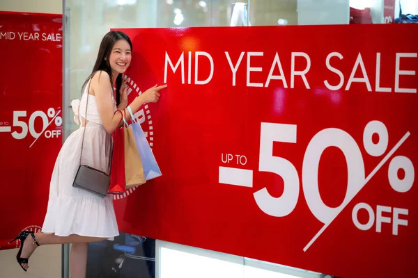 Asiatisk tjej shopping med mitten av året försäljning 50 Maxi off promotion — Stockfoto