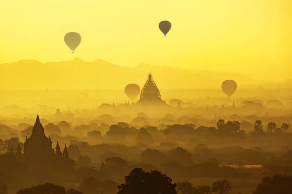 Ancient temple and hot air balloon fly over sky in Bagan after s